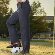 man standing , football is under his foot